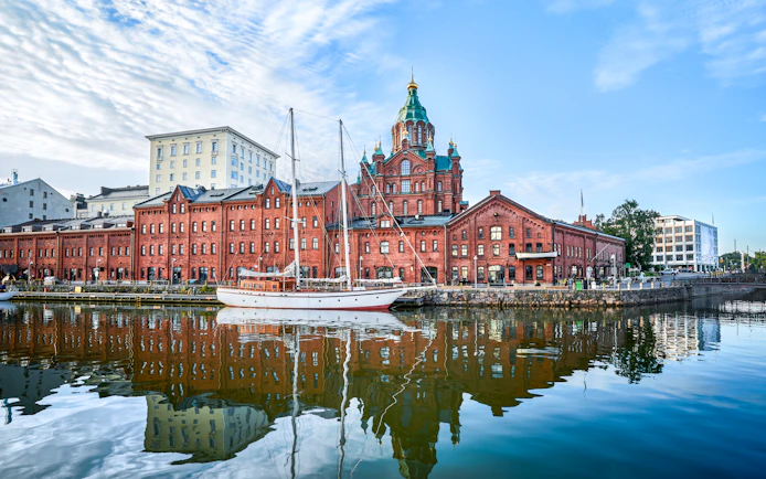 Seaside view of Uspenski Cathedral and red brick buildings in Helsinki, Finland.