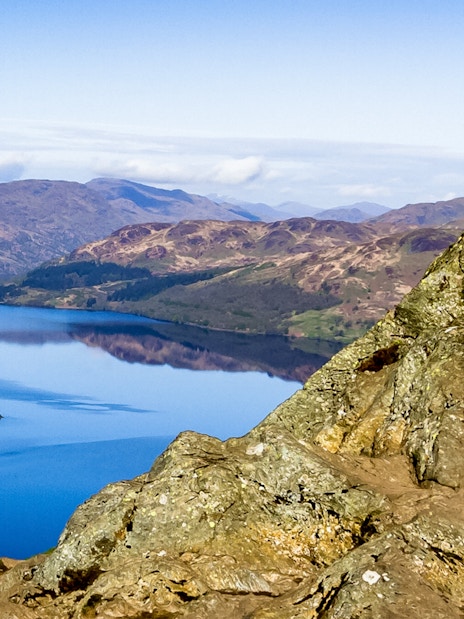 Loch Lomond view with rocky foreground and distant hills, Scotland.