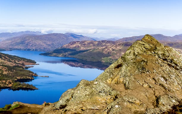 Loch Lomond view with rocky foreground and distant hills, Scotland.