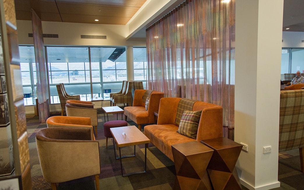 Plaza Premium Lounge seating area with armchairs and sofas near large windows.