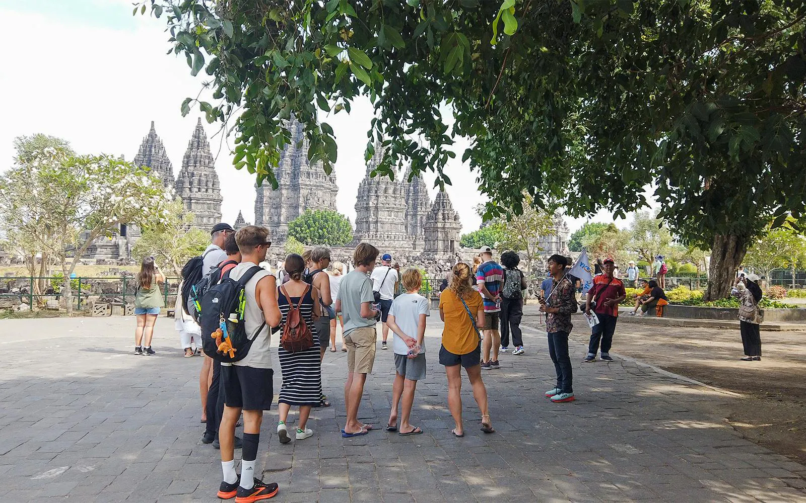 Tour group exploring Prambanan Temple complex in Yogyakarta, Indonesia.