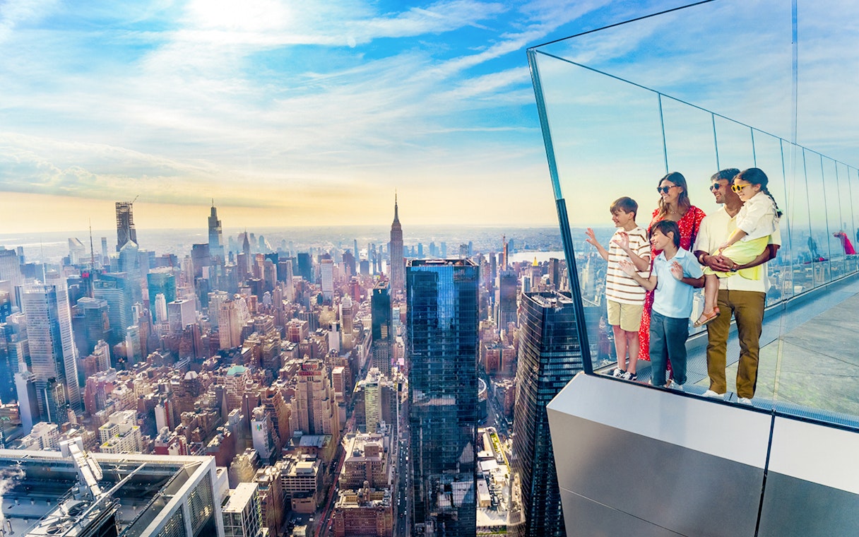 Family enjoying view from NYC observation deck with skyline and Empire State Building.