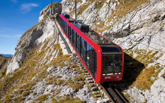 Red cogwheel train ascending Mount Pilatus near Lucerne, Switzerland.