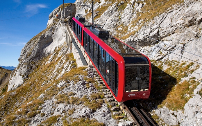 Red cogwheel train ascending Mount Pilatus near Lucerne, Switzerland.