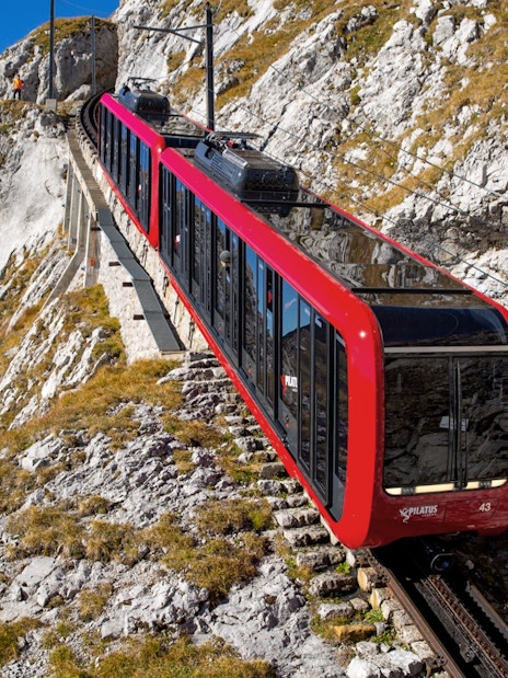 Red cogwheel train ascending Mount Pilatus near Lucerne, Switzerland.