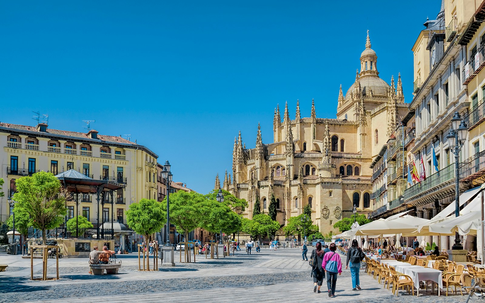 Segovia Plaza Mayor with tourists exploring historic architecture, accessible from Madrid.