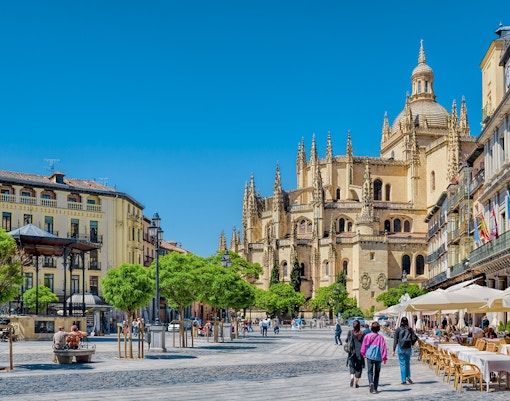 Segovia Plaza Mayor with tourists exploring historic architecture, accessible from Madrid.