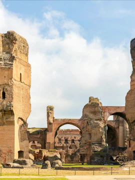Ruins of the Baths of Caracalla in Rome's historic center, showcasing ancient arches and stone structures.