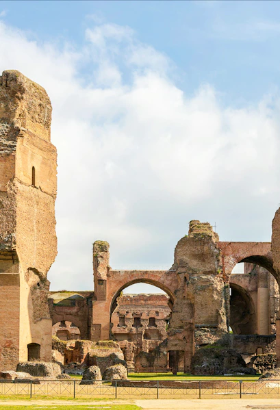 Ruins of the Baths of Caracalla in Rome's historic center, showcasing ancient arches and stone structures.