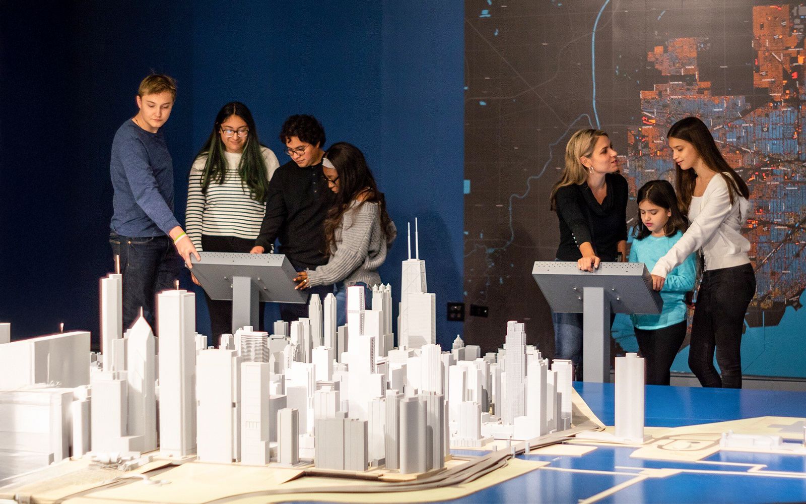 Guests interacting with a city model at the Chicago Architectural Center exhibit.