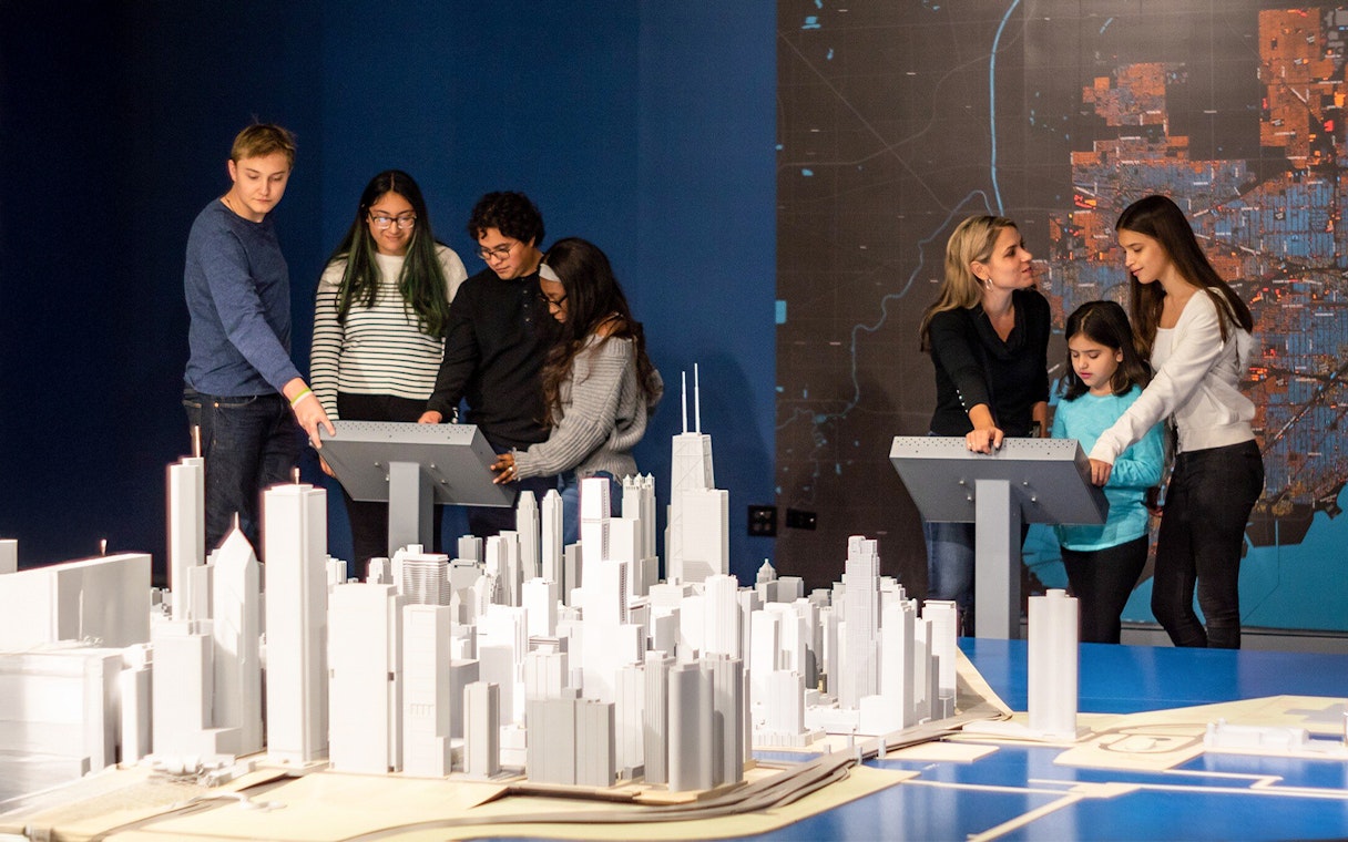Guests interacting with a city model at the Chicago Architectural Center exhibit.