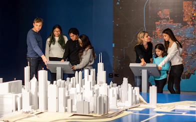 Guests interacting with a city model at the Chicago Architectural Center exhibit.