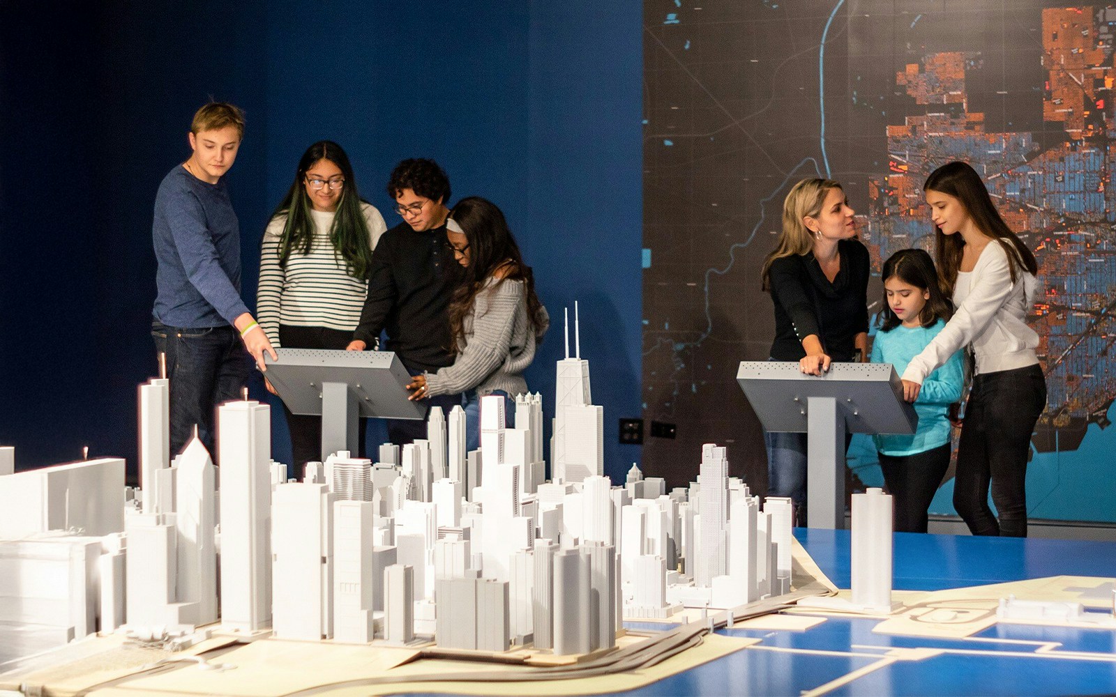 Guests interacting with a city model at the Chicago Architectural Center exhibit.