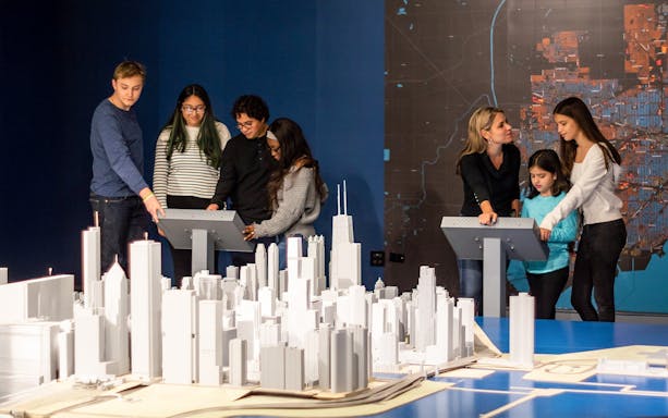 Guests interacting with a city model at the Chicago Architectural Center exhibit.
