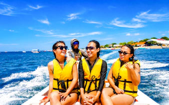 Tourists enjoying a speedboat ride in Tanjung Benoa, Bali, wearing life jackets.