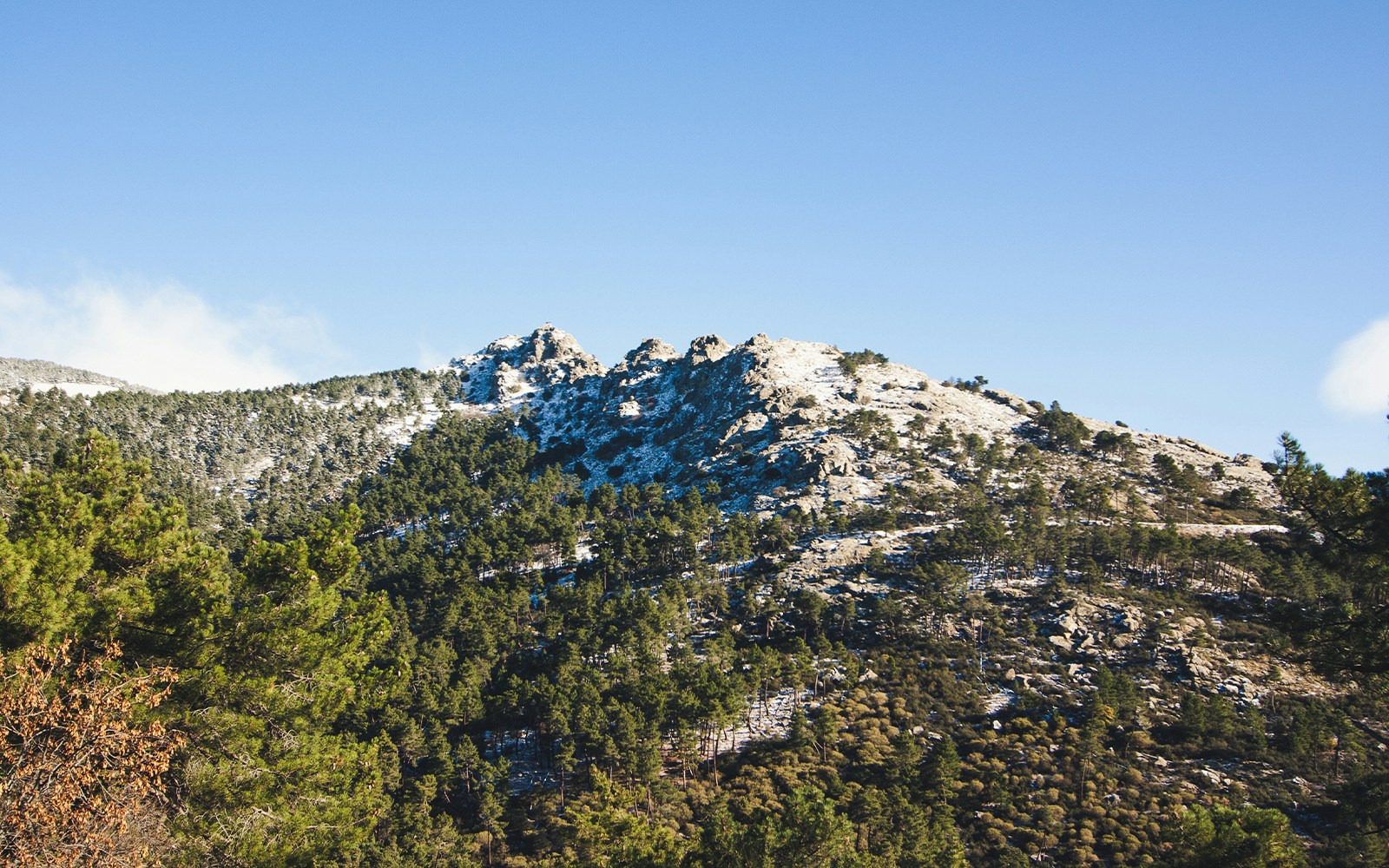 Mount Abantos with snow-dusted peaks and dense pine forests in San Lorenzo del Escorial.