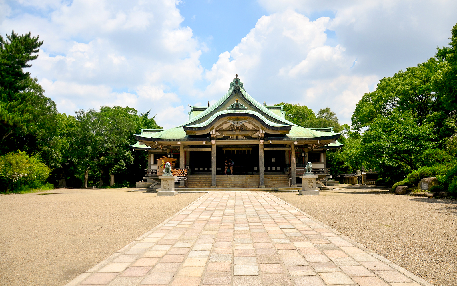 Osaka Castle courtyard with traditional Japanese architecture and surrounding greenery.