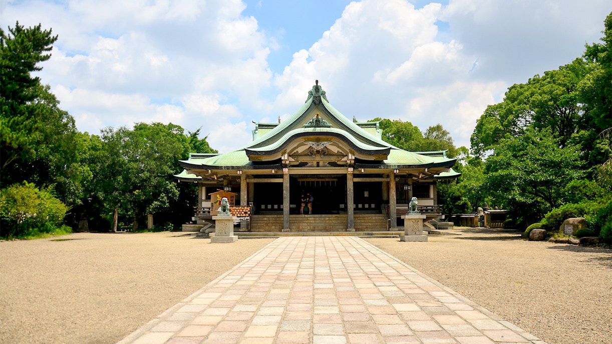 Osaka Castle courtyard with traditional Japanese architecture and surrounding greenery.