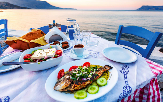 Grilled fish and Greek salad on a seaside table in Santorini.