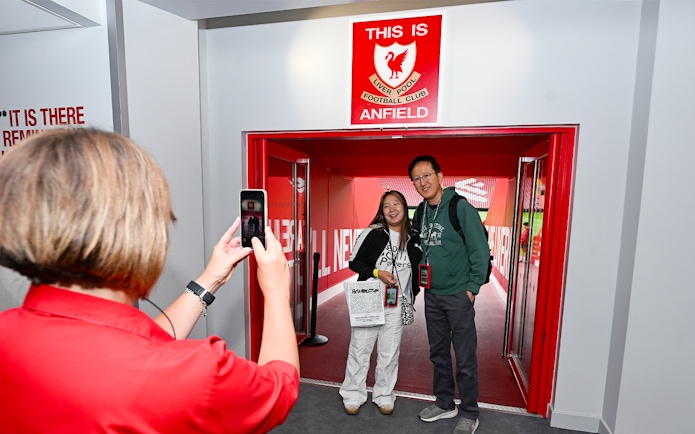 Visitors posing at Anfield entrance during Liverpool FC Stadium Tour.