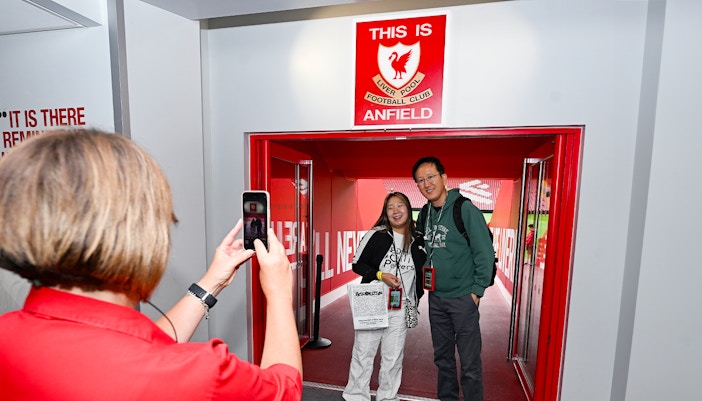 Visitors posing at Anfield entrance during Liverpool FC Stadium Tour.