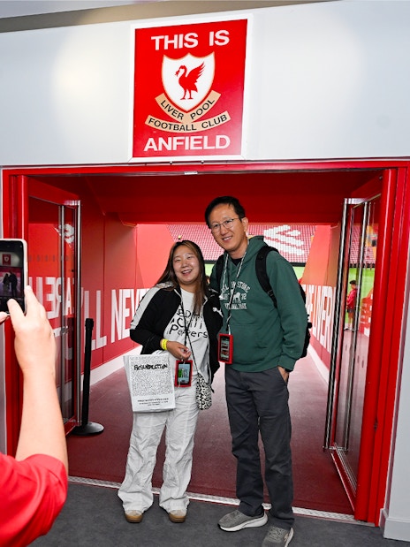 Visitors posing at Anfield entrance during Liverpool FC Stadium Tour.