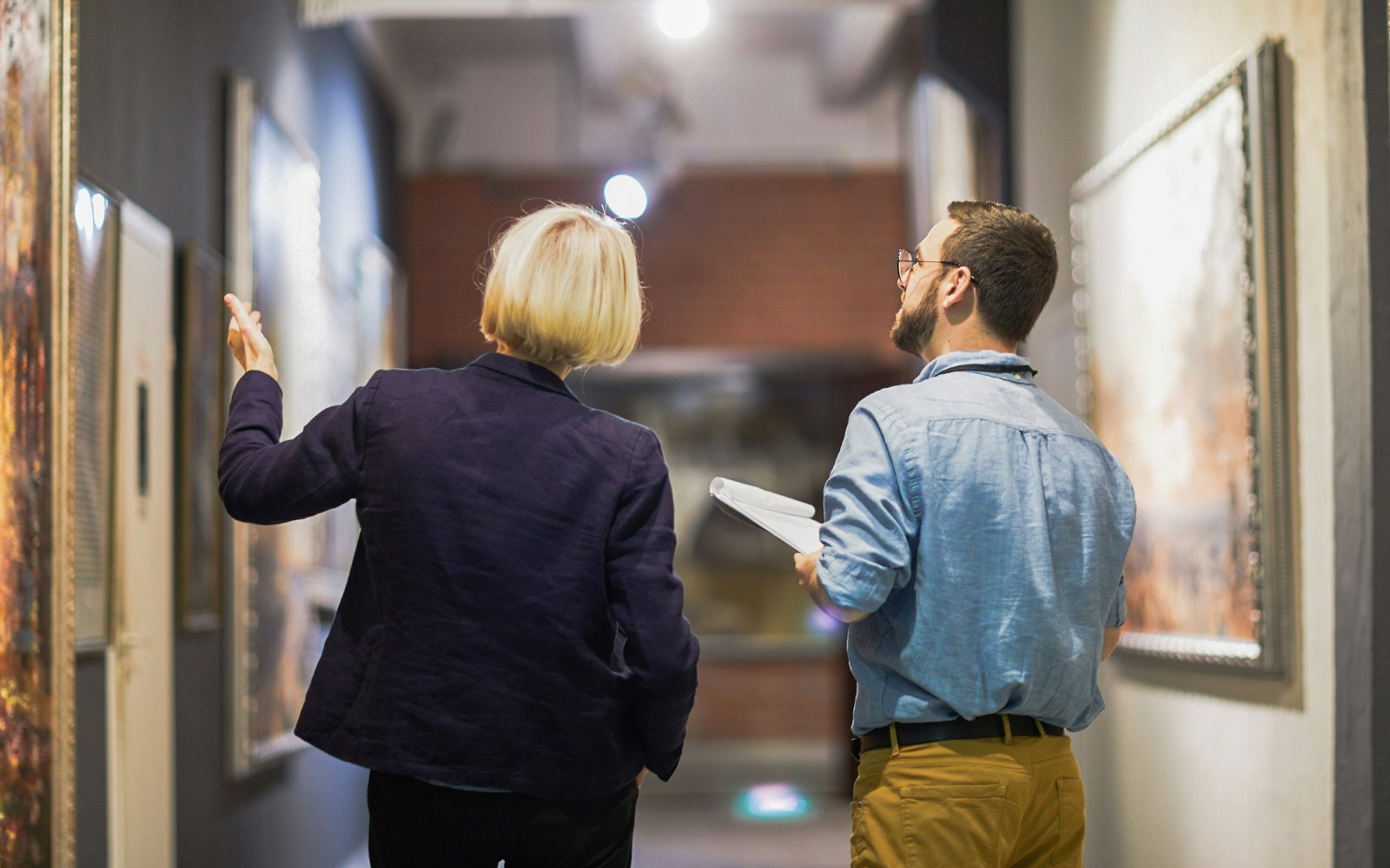 Visitors exploring contemporary art in Naples underground gallery.