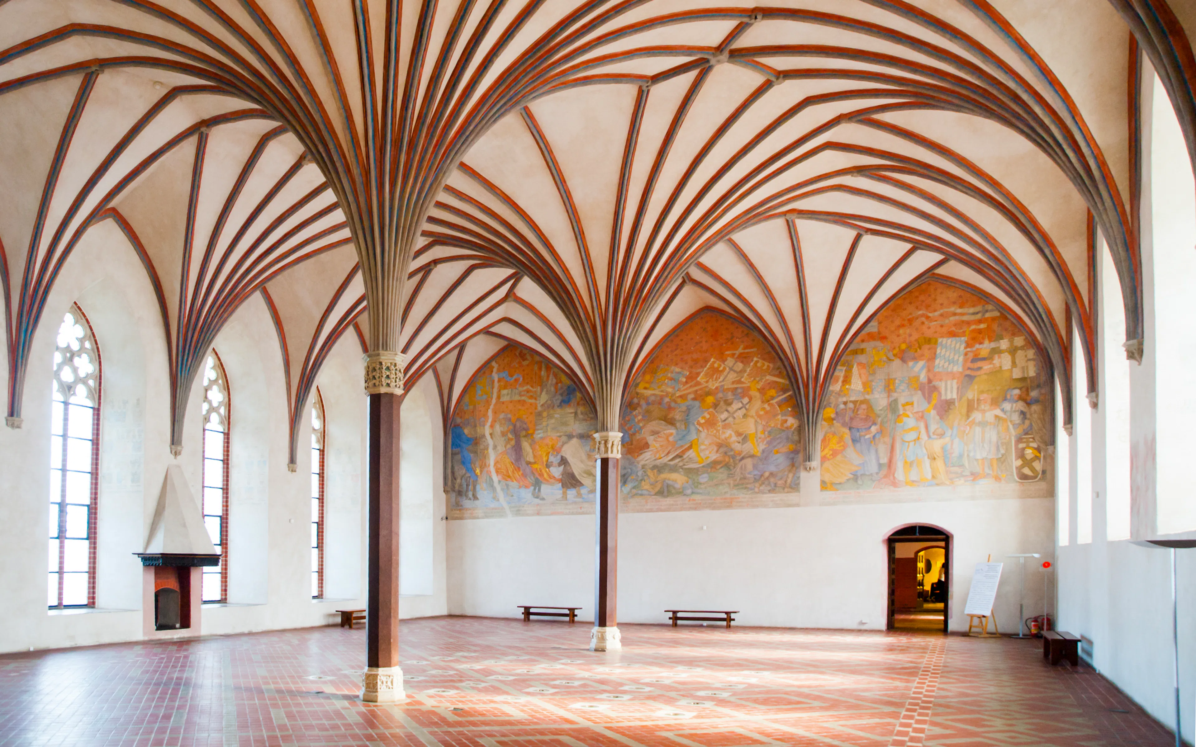 Grand Refectory at Malbork Castle with vaulted ceiling and mural.