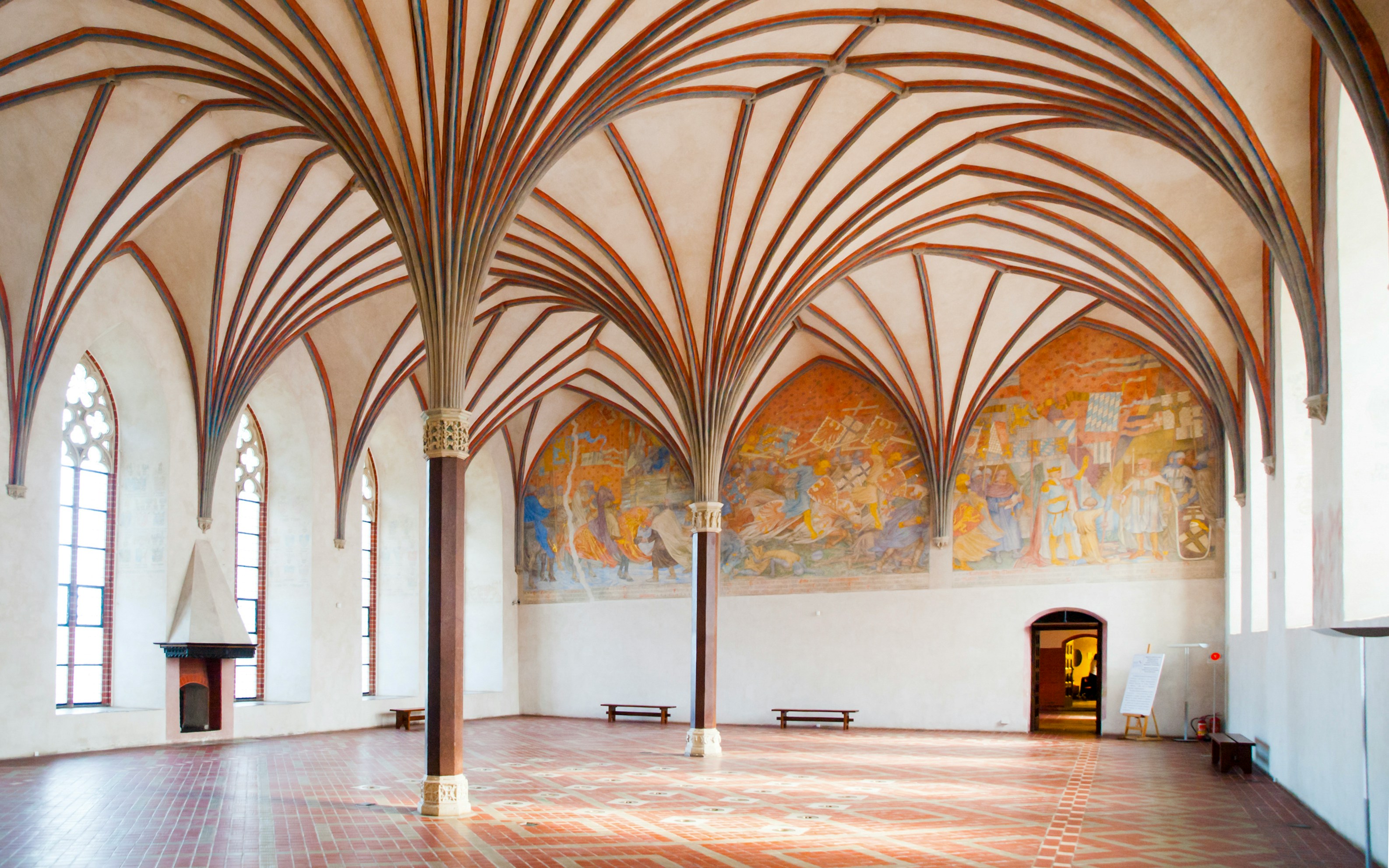 Grand Refectory at Malbork Castle with vaulted ceiling and mural.