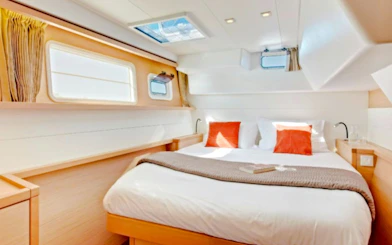 Luxurious cabin interior on Heraklion catamaran cruise with cozy bedding and natural light.
