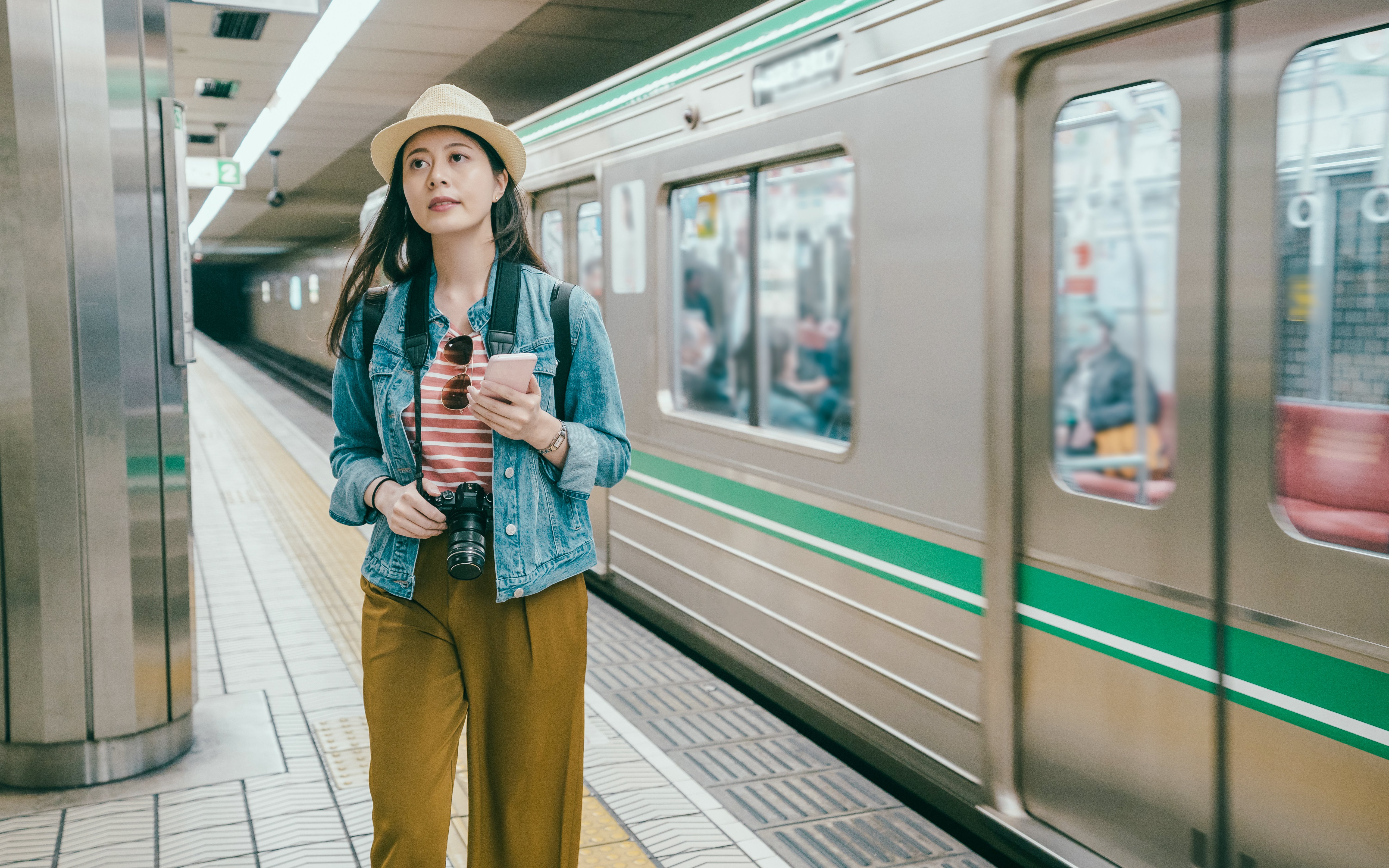 Young woman using smartphone at Osaka tube station, Japan.