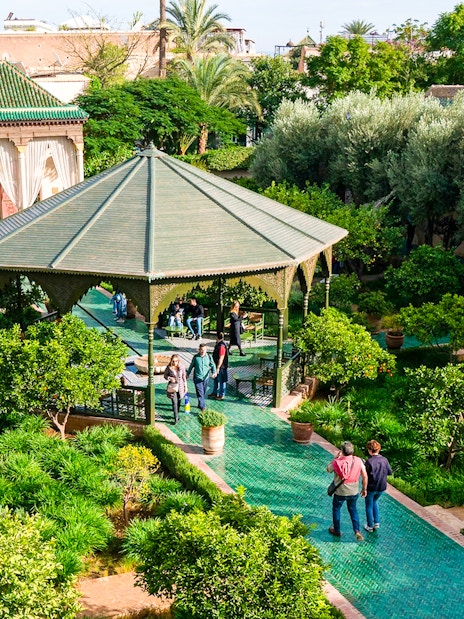 Jardin Secret garden with gazebo and visitors in Marrakech, Morocco.