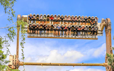 Visitors on a thrill ride at Walibi Belgium in Wavre, suspended upside down against a blue sky.