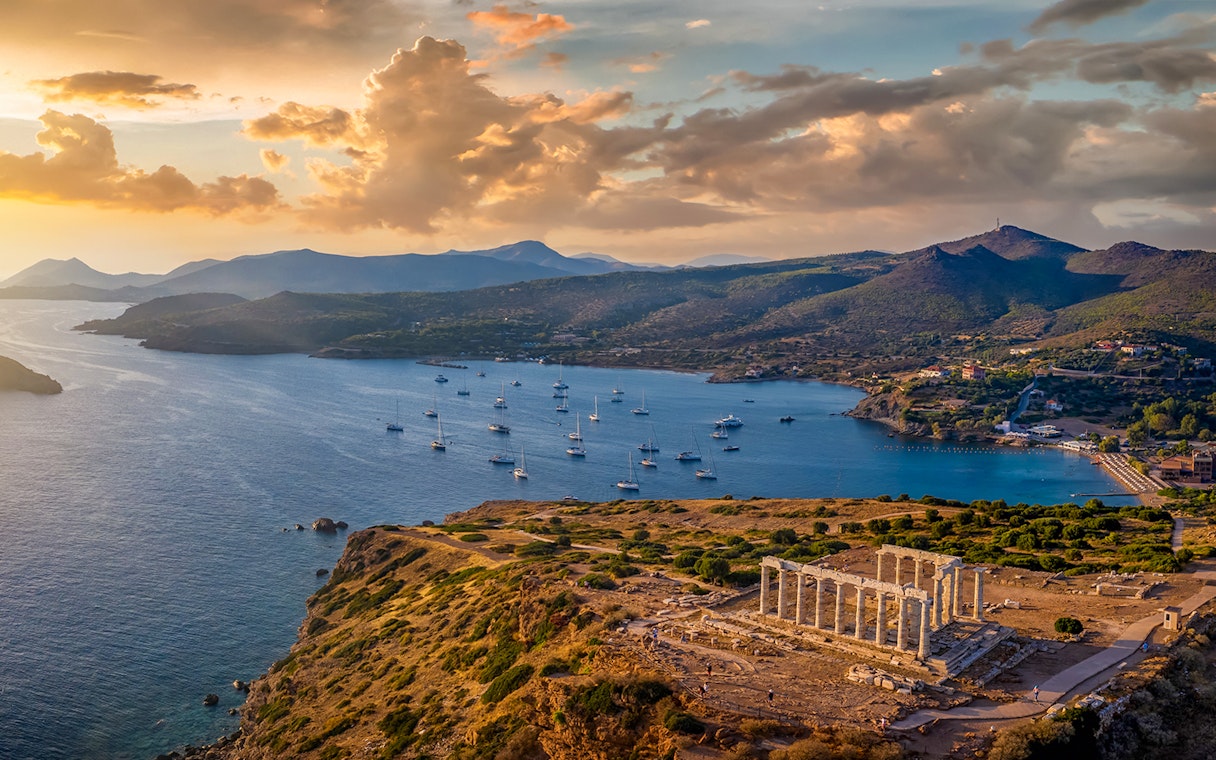 Temple of Poseidon at Cape Sounion with sunset over the Aegean Sea.