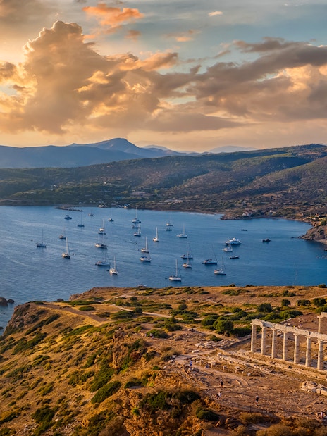 Temple of Poseidon at Cape Sounion with sunset over the Aegean Sea.