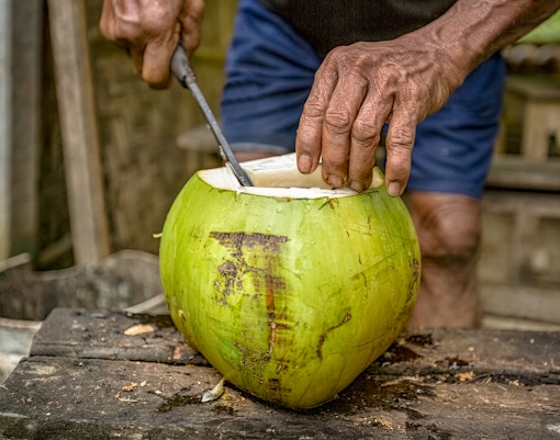 Man slicing coconut in Bali.