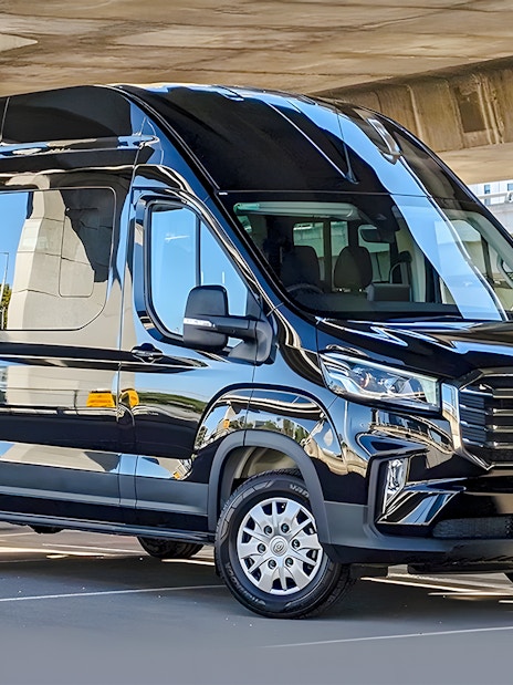 Luxury transfer bus for Great Ocean Road Reverse Tour parked under a bridge.