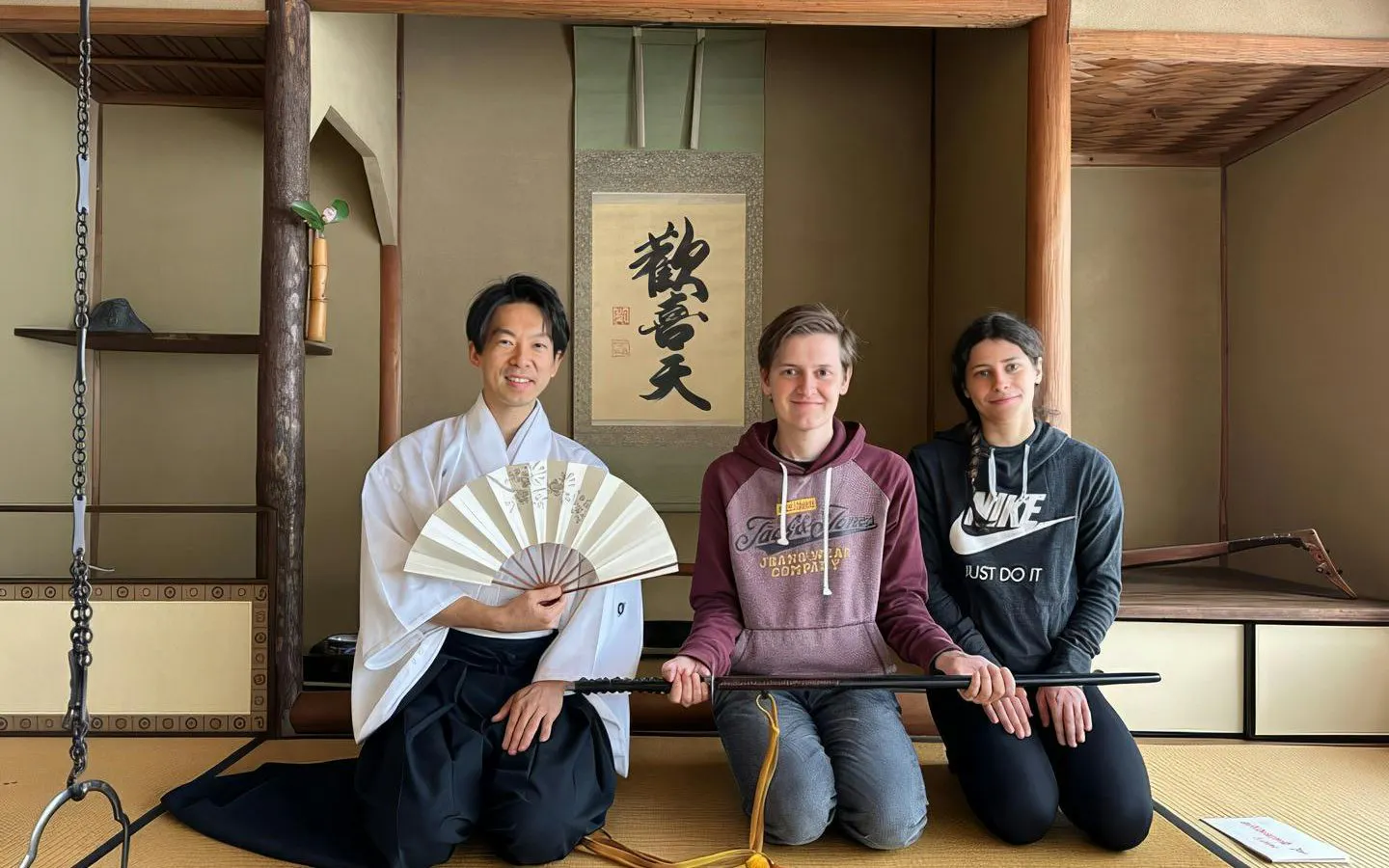 Guests at Osaka samurai sword training in a traditional Japanese room.