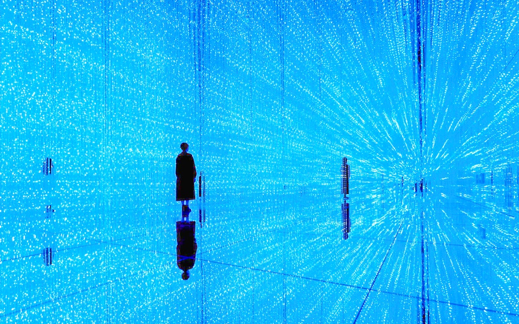 Visitor in illuminated digital art installation at teamLab SuperNature Macau.