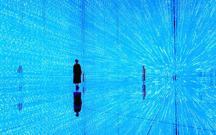 Visitor in illuminated digital art installation at teamLab SuperNature Macau.