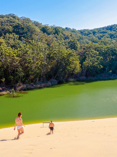 Visitors descending sand dune towards Lake Wabby on Fraser Island, K'gari.