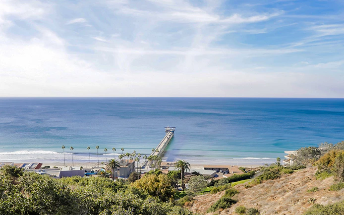 San Diego coastline with pier extending into the ocean, view from hillside.