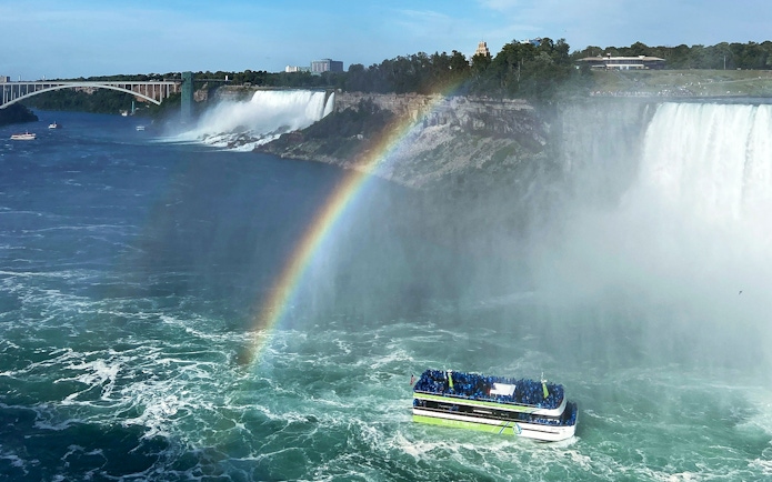 Boat near Niagara Falls with rainbow in the mist.