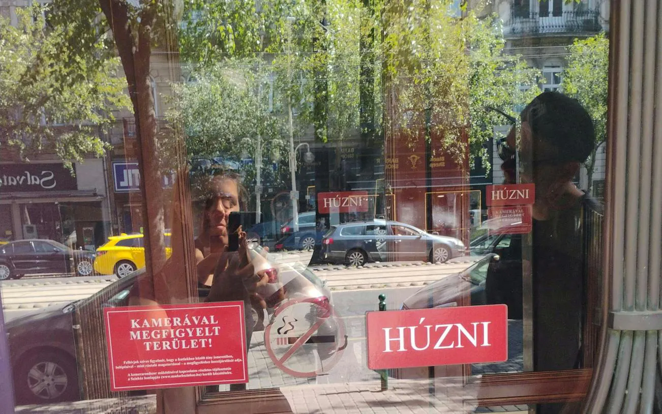 Reflection in a Budapest shop window with street view, part of the Golden Age Sweet Tastes tour.