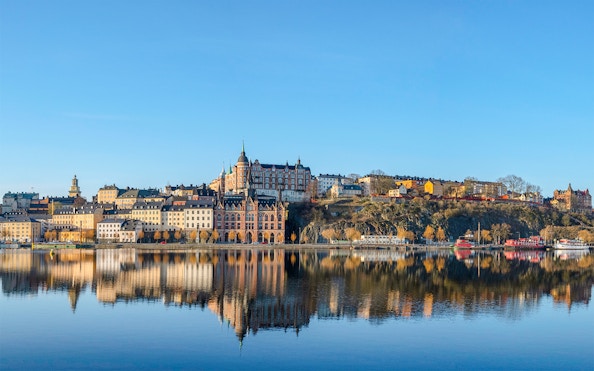 Old houses in the Södermalm district reflected in water during an Archipelago Sightseeing Cruise.