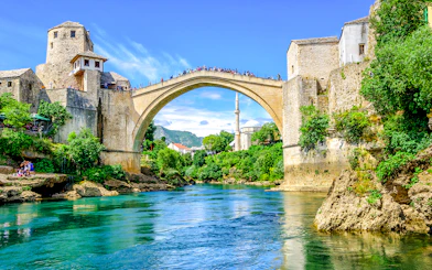 Old Bridge and mosque in Mostar's Old Town, Bosnia, over a turquoise river.