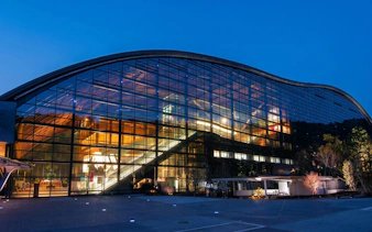 Kyushu National Museum glass facade illuminated at night, Japan.