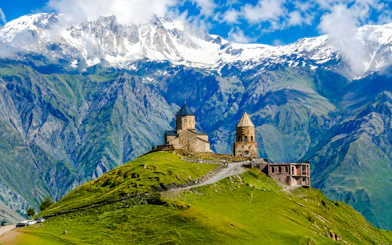 Gergeti Trinity Church on a hill with the Caucasus Mountains in Kazbegi, Georgia.