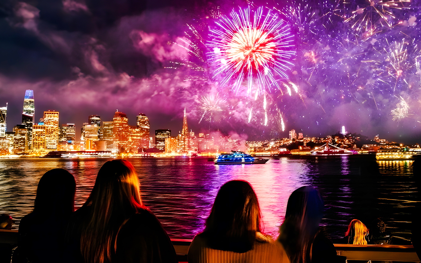 Guests watching fireworks over city skyline on New Year's Eve dinner cruise.