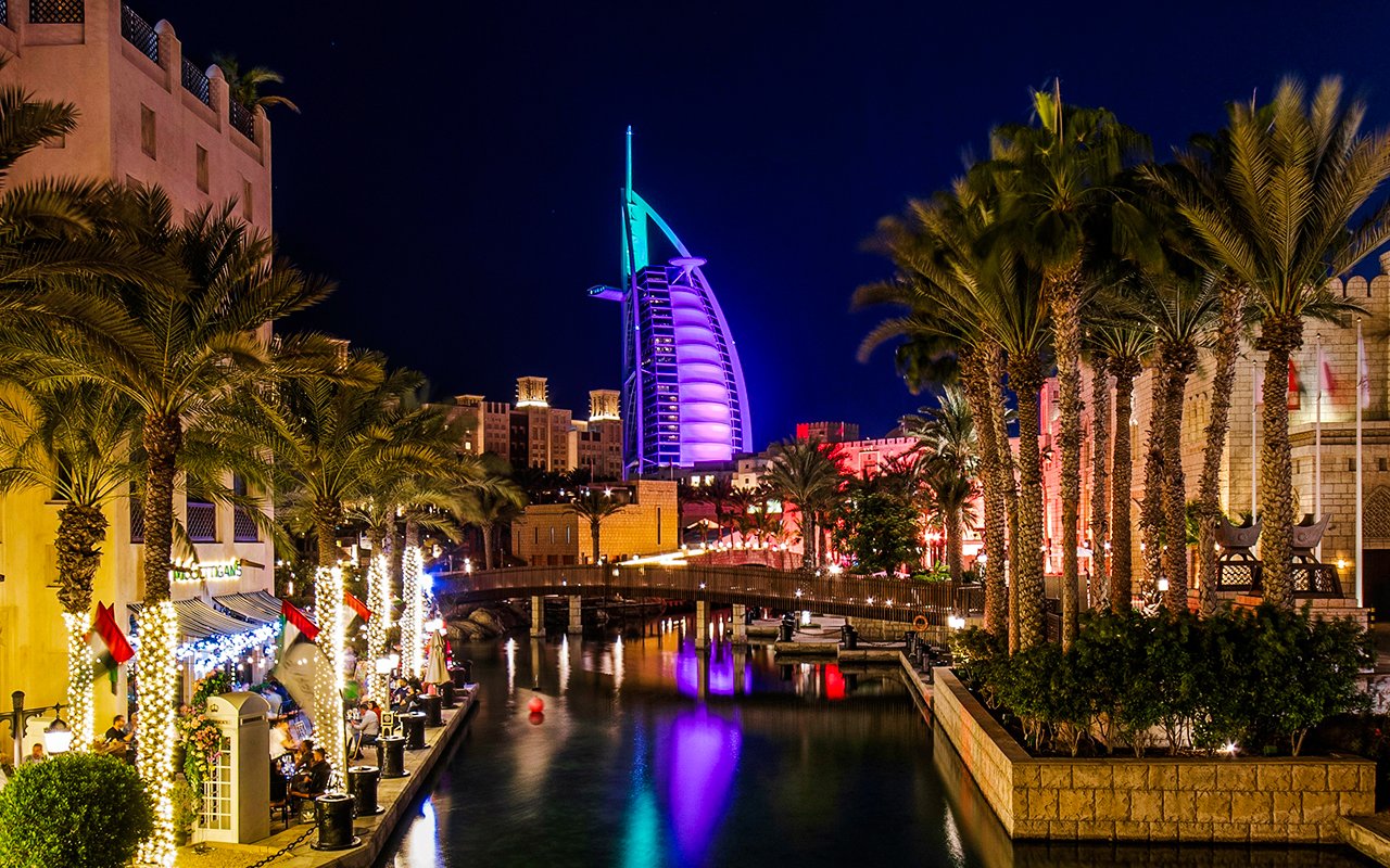Madinat Jumeirah canal at night with Burj Al Arab illuminated in the background, Dubai.